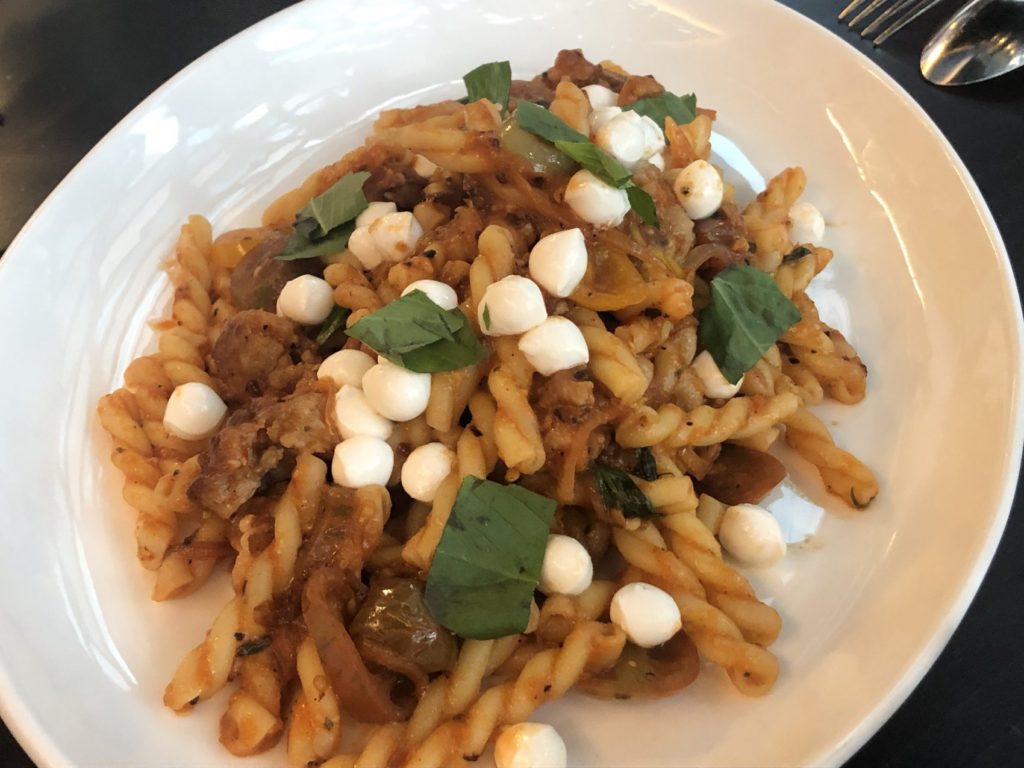 For pasta lovers, the gemelli with sweet Italian sausage, shallots, roasted eggplant, heirloom tomatoes, and fresh mozzarella is a must-try. 